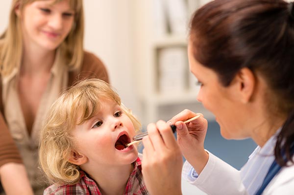 doctor examining a child's throat
